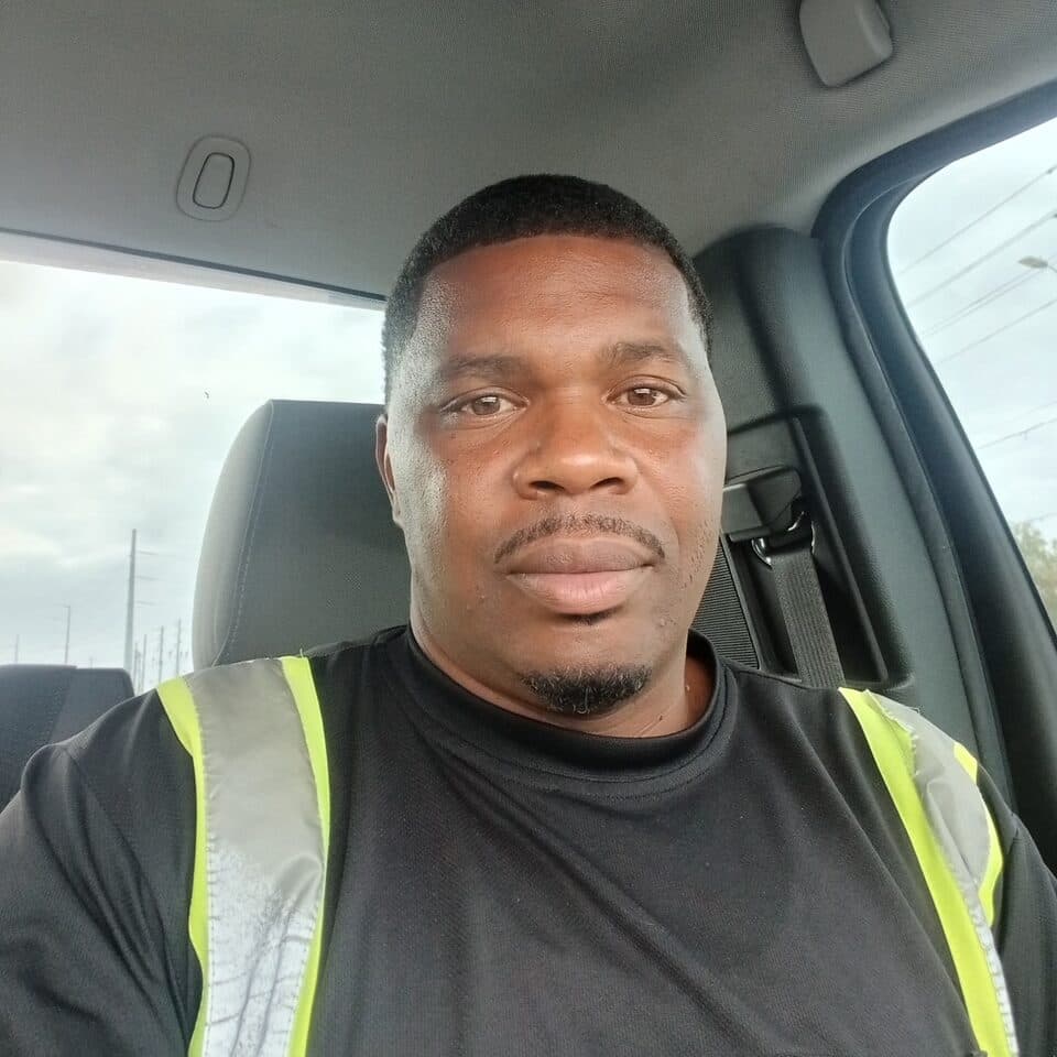 Jason, the owner of Above Average Towing, in the cab of his truck wearing a hi-vis work vest