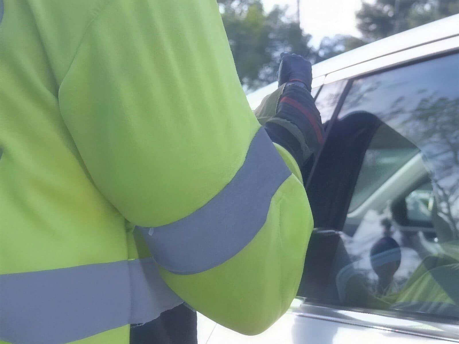Reaching through a car window with a lockout tool to open the door